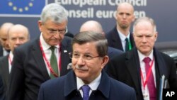 ນາຍົກລັດຖະມົນຕີເທີກີ ທ່ານ Ahmet Davutoglu, ກາງ, ເດີນທາງໄປເຖິງກອງປະຊຸມສຸດຍອດ ສະຫະພາບຢູໂຣບ ທີ່ນະຄອນຫລວງ Brussels ວັນສຸກ ທີ 18, 2016.