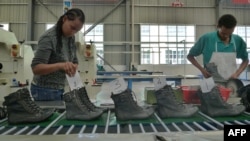 People work on the assembly line at a shoe factory in Dukem, Ethiopia, April 19, 2012.