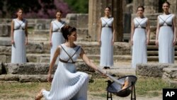 La llama olímpica fue encendida por la actriz Katerina Lehou, representando una suma sacerdotisa pagana, el miércoles 20 de abril de 2016, en la Antigua Olimpia, Grecia.
Actress Katerina Lehou, right, as high priestess, lights the Olympic Flame, during the final dress rehearsal of the lighting of the Olympic flame at Ancient Olympia, in western Greece, April 20, 2016.