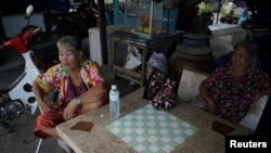 Somjit Teeraroj (L), 77, and Poonsri Seangnual (R), 63, who study at the School for the Elderly in Chiang Rak Noi subdistrict, spend time with each other at a shop in Ayutthaya, Thailand, April 26, 2018.