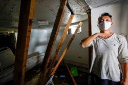Danny Hong shows where floodwater reached up to him as he shows the damage in his basement apartment in the Flushing neighborhood of the Queens borough of New York, Sept. 2, 2021.