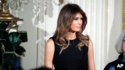 First lady Melania Trump attends a Hanukkah reception in the East Room of the White House, while her husband President Donald Trump speaks, Dec. 7, 2017, Washington. 