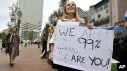 A woman who identified herself only as Jenna, and said she worked at an architecture firm in Boston's financial district, stops on her way to work to join demonstrators with Occupy Boston on Monday, Oct. 3, 2011.