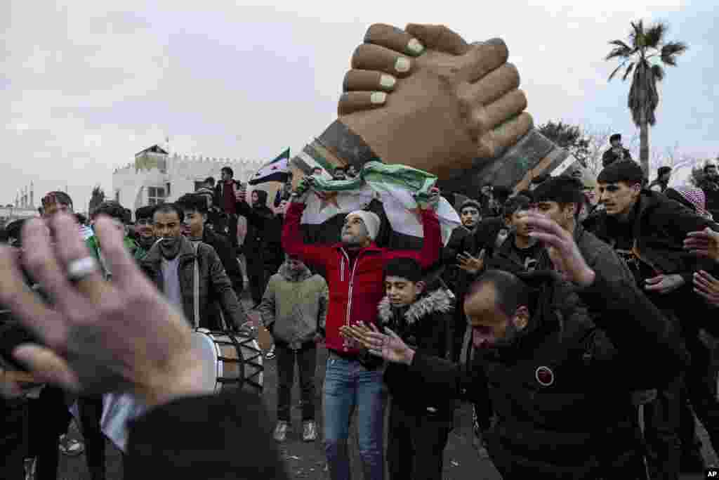 People gather to celebrate the fall of the Syrian government, in Manbij.