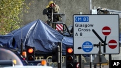 Petugas pemadam kebakaran dan penyelamatan Skotlandia di lokasi jatuhnya helikopter di Clutha Bar, Glasgow (30/11). (AP/Scott Heppell)