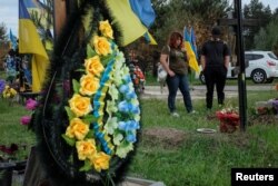 Reaksi Tetiana Vatsenko-Bondareva saat mengunjungi makam suaminya Denys Bondarev, 38, di tengah serangan Rusia ke Ukraina, di pemakaman di Poltava, Ukraina, 25 Mei 2023. (Foto: REUTERS/Dan Peleschuk)