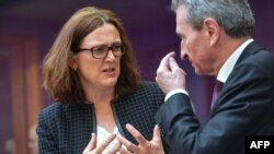 European Commissioner for Trade Cecilia Malmstrom (L) speaks with EU Commissioner of Digital Economy & Society Gunther Oettinger during the Weekly College meeting at the European Commission headquarters in Brussels, Belgium, April 3, 2019.