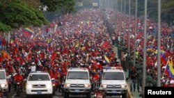Thousands of people follow the funeral parade of Venezuela's late President Hugo Chavez in Caracas, March 15, 2013. 