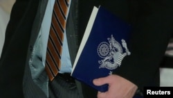 FILE - A member of the U.S. trade delegation to China, carries a folder as he leaves a hotel in Beijing, China January 7, 2019. 