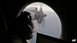 Petugas di atas pesawat Angkatan Udara Australia yang mencari pesawat Malaysia Airlines Penerbangan MH370 di bagian selatan Samudera Hindia, 2014. (AP/Rob Griffith)