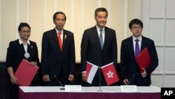 Dari kiri: Menlu Indonesia Retno L.P. Marsudi, Presiden Indonesia Joko Widodo, Pimpinan Eksekutif Hong Kong, Leung Chun-ying dan Menteri yang membawahi bidang Pekerja Srephen SUi, berpose seusai penandatangan nota kesepakatan di Hong Kong, China , 1 Mei 2017. (Jerome Favre/Pool Photo via AP).