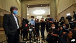 FILE - Steven Gan, left, editor-in-chief of Malaysiakini online news portal, arrives at court in Putrajaya, Malaysia, July 13, 2020. 