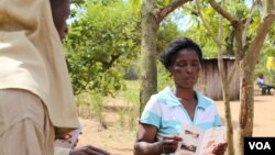 Information teams are chosen from the communities to disseminate information about residual spraying. They go door-to-door explaining the process and when it will take place, Mozambique, Nov. 13, 2014. (Gillian Parker/VOA)