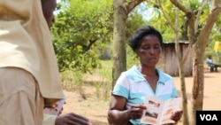 Information teams are chosen from the communities to disseminate information about residual spraying. They go door-to-door explaining the process and when it will take place, Mozambique, Nov. 13, 2014. (Gillian Parker/VOA)