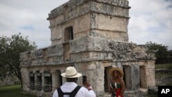 Un turista posa para una foto durante una visita a las ruinas mayas de Tulum en el estado de Quintana Roo, México, el martes 5 de febrero de 2021.