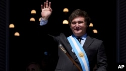 Argentina's newly sworn-in President Javier Milei waves to supporters from the balcony of the government house in Buenos Aires, Argentina, Sunday, December 10, 2023. 