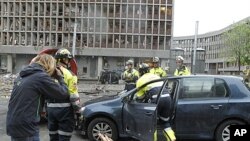 Rescue workers work at the scene of a powerful explosion that rocked central Oslo July 22, 2011