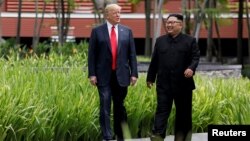 Presiden AS Donald Trump dan pemimpin Korea Utara Kim Jong Un dalam pertemuan di Singapura, 12 Juni lalu. 