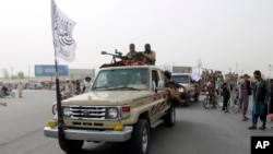 Taliban fighters patrol on the road during a celebration marking the second anniversary of the withdrawal of U.S.-led troops from Afghanistan, in Kandahar, south of Kabul, Afghanistan, Aug. 15, 2023.