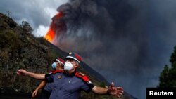 Police officers block a road as lava rises following the eruption of a volcano on the Island of La Palma, in Tacande, Spain, September 22, 2021.