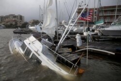 Un bote queda medio hundido en un muelle de la ciudad de Pensacola, Florida, al paso del huracán Sally el 16 de septiembre de 2020.