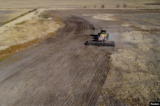 An agricultural worker operates farming equipment to plant wheat on farmland in Comodoro Py, outside of Buenos Aires, Argentina on June 21, 2022. (REUTERS/Matias Baglietto)