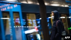A commuter wearing a protective face mask waits for the metro at Stockholm's central station, Dec. 3, 2020.