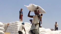 FILE - Men deliver U.N. World Food Program (WFP) aid in Aslam, Hajjah, Yemen, Sept. 21, 2018.