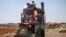 A Syrian family rides with belongings on a tractor-drawn trailer as they flee from fighting in the southern Syrian province of Daraa, June 21, 2018.