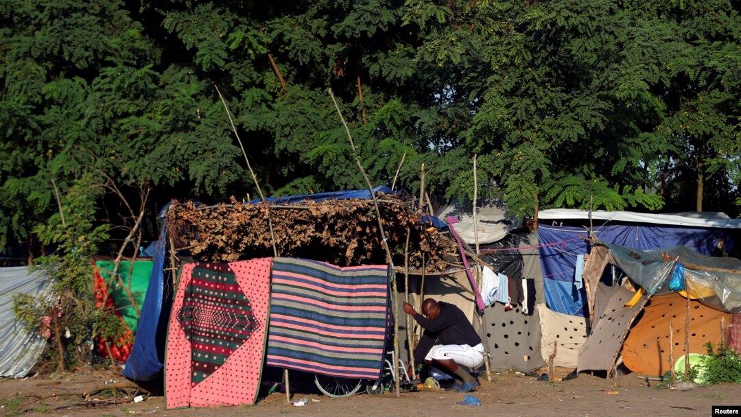 A refugee cleans his tent in a makeshift camp on the Hungary-Serbia border, on the Serbian side of a transit zone set up by Hungarian authorities to filter refugees at Roszke, Hungary, Sept. 2, 2016. 