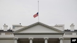 A U.S. flag is seen at half-staff over the White House in Washington, Friday, July 20, 2012. President Barack Obama ordered the flag to be lowered in the aftermath of the tragic mass shooting at a movie theater in Aurora, Colorado.