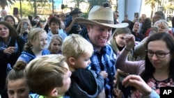 Ammon Bundy, center, a son of Nevada rancher and states' rights figure Cliven Bundy, is greeted by family and friends at the U.S. District Courthouse in Las Vegas after being released from federal custody, Nov. 30, 2017. A federal judge ordered Bundy freed to house arrest during his trial on charges in an armed standoff with U.S. Bureau of Land Management agents near the Bundy ranch in Nevada. 