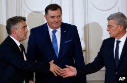 FILE - Members of Bosnia's newly elected tripartite presidency, Bosnian Serb member Milorad Dodik, center, Croat member Zeljko Komsic, left, and Muslim member Sefik Dzaferovic, greet each other, in Sarajevo, Nov. 20, 2018.