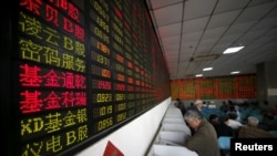 Investors look at computer screens showing stock information at a brokerage house in Shanghai, China, April 21, 2016.