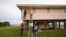 Jerry McCullen, top of ladder left, and Carson Baze, top of ladder right, put plywood over the windows of a house ahead of Hurricane Helene, expected to make landfall Thursday evening, in Alligator Point, Florida, Sept. 25, 2024.