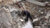 Un hombre avanza entre escombros tras un ataque israelí, el domingo 14 de enero de 2024, en Deir al Balah, Franja de Gaza.