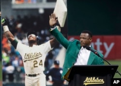 FILE - Former baseball player Rickey Henderson waves after speaking during a ceremony inducting him into the Oakland Athletics' Hall of Fame before a baseball game between the Athletics and the New York Yankees in Oakland, Calif., Sept. 5, 2018.