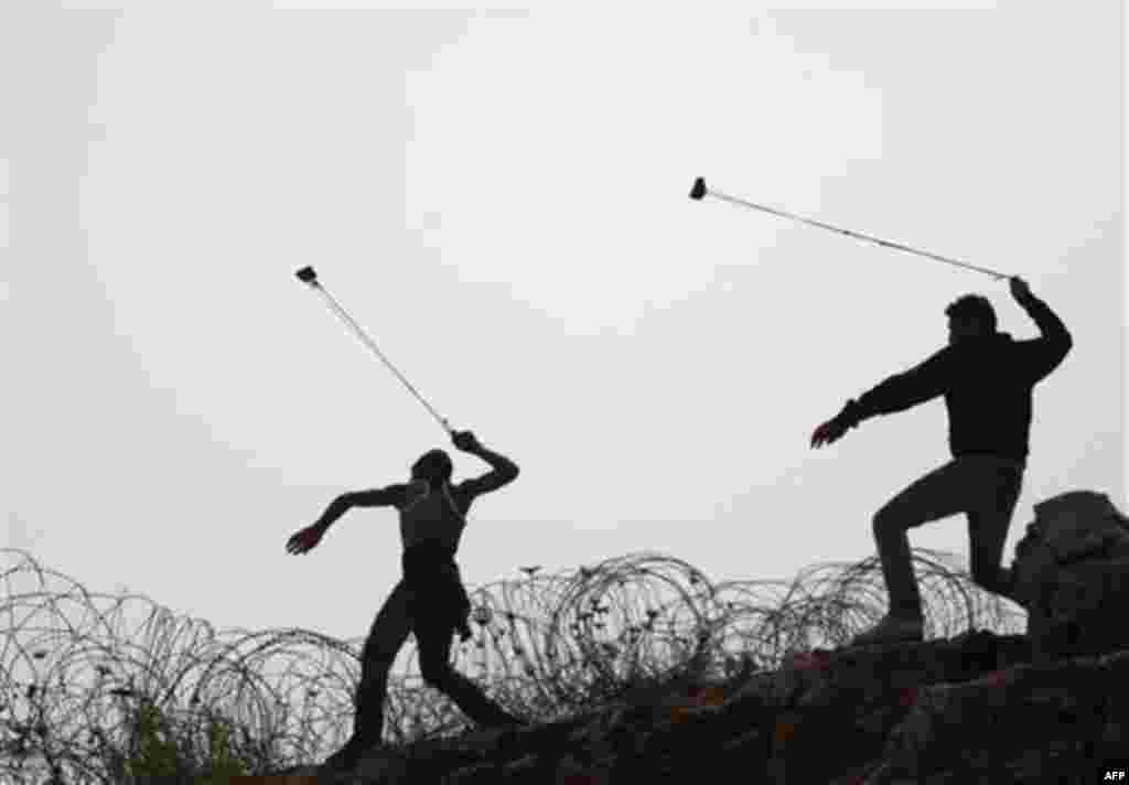 Palestinians wield a sling-shots at Israeli troops during clashes outside Israeli military prison Ofer near the West Bank city of Ramallah. Friday, Oct. 21, 2011. AP Photo/Majdi Mohammed)