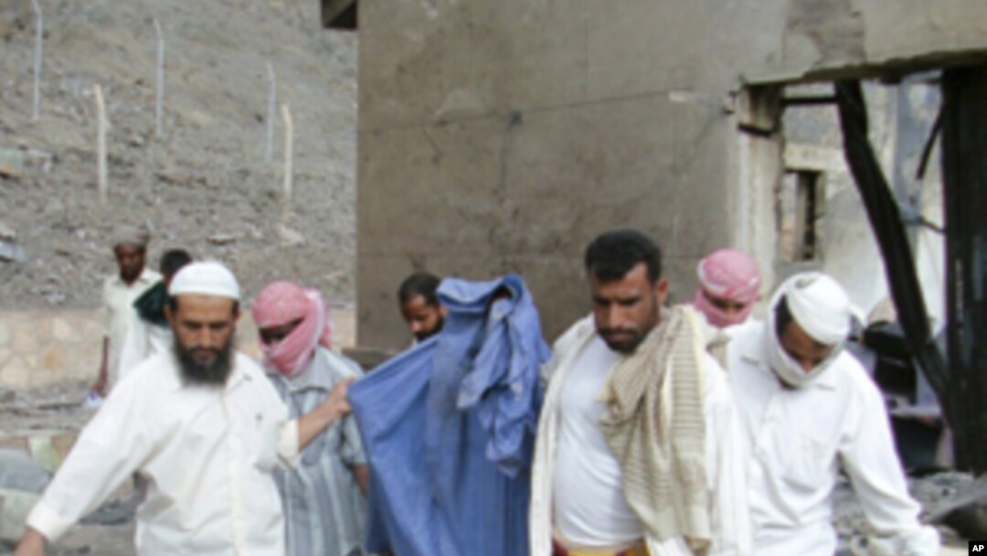 People carry the remains of a victim killed in an explosion at a bullet factory in the southern Yemeni town of Jaar, March 28, 2011.