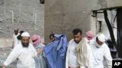 People carry the remains of a victim killed in an explosion at a bullet factory in the southern Yemeni town of Jaar, March 28, 2011.