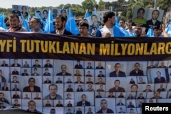FILE - Ethnic Uyghurs display a banner and hold East Turkestan flags during a protest against China near the Chinese Consulate in Istanbul, Turkey, May 26, 2022. (REUTERS/Umit Bektas)