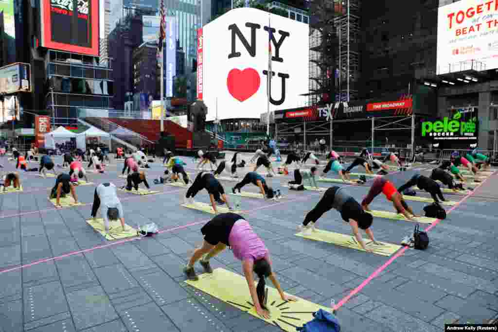 Pessoas participam no evento de celebra&#231;&#227;o do solst&#237;cio na Times Square em Nova Iorque (&quot;Solstice in Times Square: Mind Over Madness Yoga&quot;). 20 de Junho, 2021