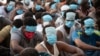 People from China, Vietnam and Ethiopia, believed to have been trafficked and forced to work in scam centers, sit with their faces masked while in detention after being released from the centers in Myawaddy district in eastern Myanmar, Feb. 26, 2025. 