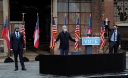 FILE - U.S. President-elect Joe Biden stands between Democratic U.S. Senate candidates Rev. Raphael Warnock and Jon Ossoff ahead of their January 5 runoff elections, at Pullman Yard in Atlanta, Georgia, Dec. 15, 2020.