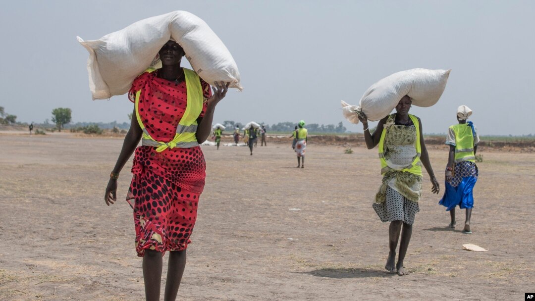 A women walk back to their homes after receiving food distributed by ICRC at a site in Leer County region of South Sudan, Tuesday, April 11, 2017. Two months after a famine was declared in two counties amid its civil war, hunger has become more widespread than expected, aid workers say, region on the brink of starvation and people at risk of dying without sustained food assistance.