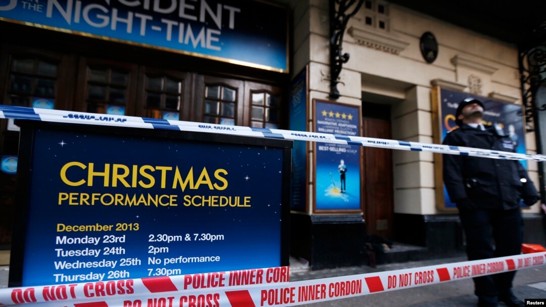Seorang polisi tengah berjaga dekat papan pengumuman yang diberi garis polisi di luar Theater Apollo, London (20/12).