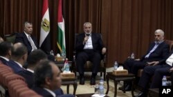 Head of the Hamas political bureau, Ismail Haniyeh, center, and Hamas leader in the Gaza Strip Yahya Sinwar, right, meet with Egypt's general intelligence chief, Khaled Fawzy, and others in Haniyeh's office in Gaza City, ahead of talks in Cairo, Oct. 3, 2017.