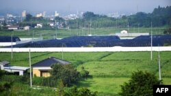 File -- Picture shows radiated surface soil covered by black tarps, at a decontaminated field in Futaba, Fukushima prefecture, August 2, 2019. (Photo by CHARLY TRIBALLEAU / AFP)