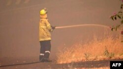 호주 방송국(ABC)이 21일 촬영해 공개한 영상에서 소방관이 퍼스 동쪽 파커빌 교외에서 산불 진압을 시도하고 있다.