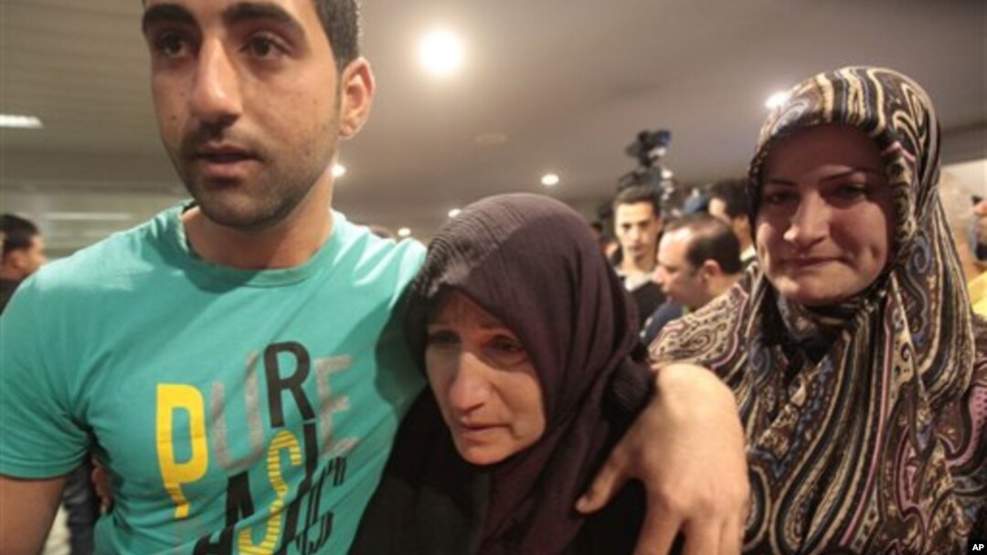 Salah seorang wanita Lebanon yang diculik di Suriah dan telah dibebaskan, dijemput kedua anaknya setibanya di bandara internasional Rafik Hariri, Beirut, Lebanon (23/5)/ 